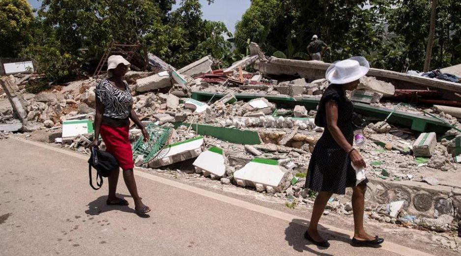 Dos mujeres caminan junto a una vivienda derrumbada durante el terremoto del pasado 14 de agosto, hoy, en Marceline, Haití. EFE/O. Barría