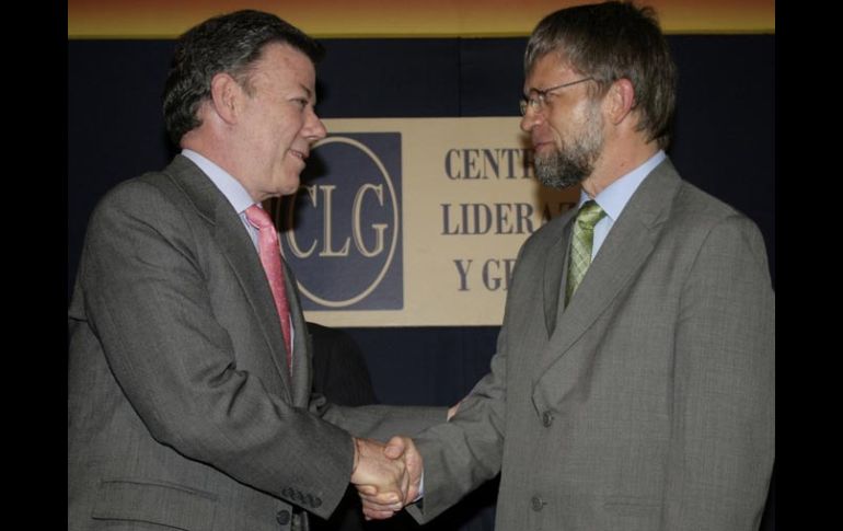 Juan Manuel Santos (izquierda), candidato del Partido de la U, se saluda con Antanas Mockus, del Verde, en un debate en Bogotá. AP  /