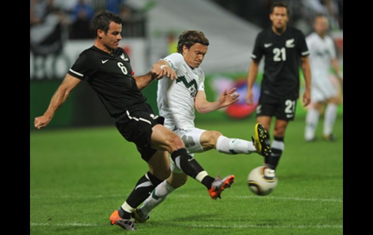 Ryan Nelsen de Nueva Zelandia, compite con Zlatko Dedic de Eslovenia durante el partido amistoso en Maribor. AFP  /