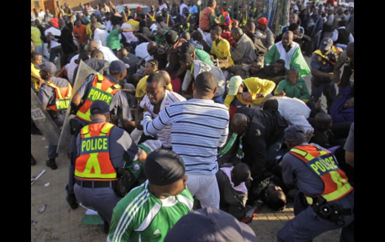 La policía trata de controlar a los aficionados que provocaron una estampida en una juego amistoso entre Nigeria y Corea del Norte. AP  /