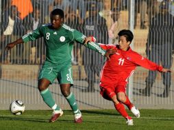 El nigeriano Yakubu Aiyegbeni disputa el balón con el jugador de Corea del Norte Mun In-guk. AFP  /