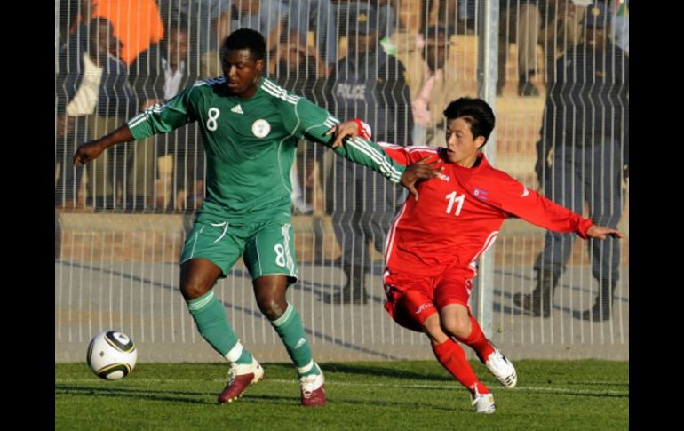 El nigeriano Yakubu Aiyegbeni disputa el balón con el jugador de Corea del Norte Mun In-guk. AFP  /