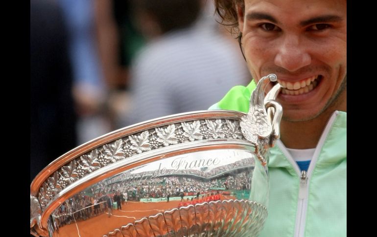 Rafael Nadal muerde el trofeo que lo acredita como el ganador del torneo Roland Garros. AP  /