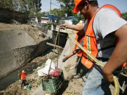 Trabajadores municipales limpian el canal de aguas residuales sobre avenida Gobernador Curiel, frente al Rastro de Guadalajara.S. NÚÑEZ  /