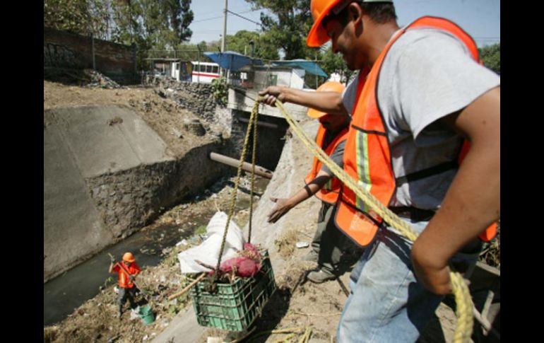 Trabajadores municipales limpian el canal de aguas residuales sobre avenida Gobernador Curiel, frente al Rastro de Guadalajara.S. NÚÑEZ  /