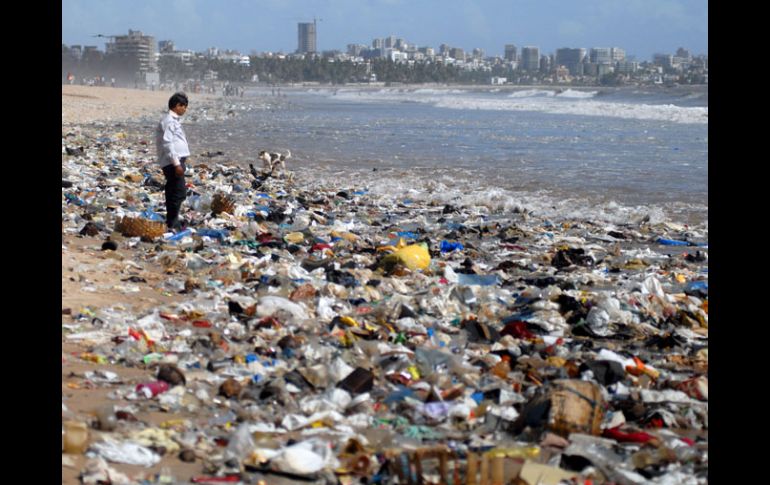 Un hombre se detiene entre restos de comida y plásticos en una playa de Juhu Chowpaty en Mumbai. EFE  /