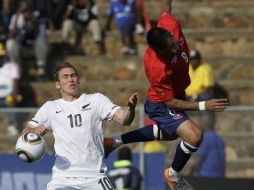 Arturo Vidal disputa una pelota con Chris Killen. AP  /