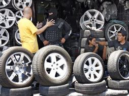 Un elemento de las fuerzas policíacas cuestiona a un comerciante en uno de los locales examinados ayer. A. GARCÍA  /