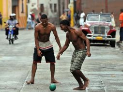 Dos jóvenes cubanos juegan con un balón, contagiados por la fiebre futbolera. EFE  /