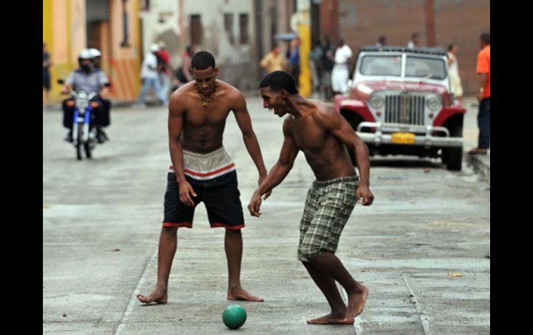 Dos jóvenes cubanos juegan con un balón, contagiados por la fiebre futbolera. EFE  /