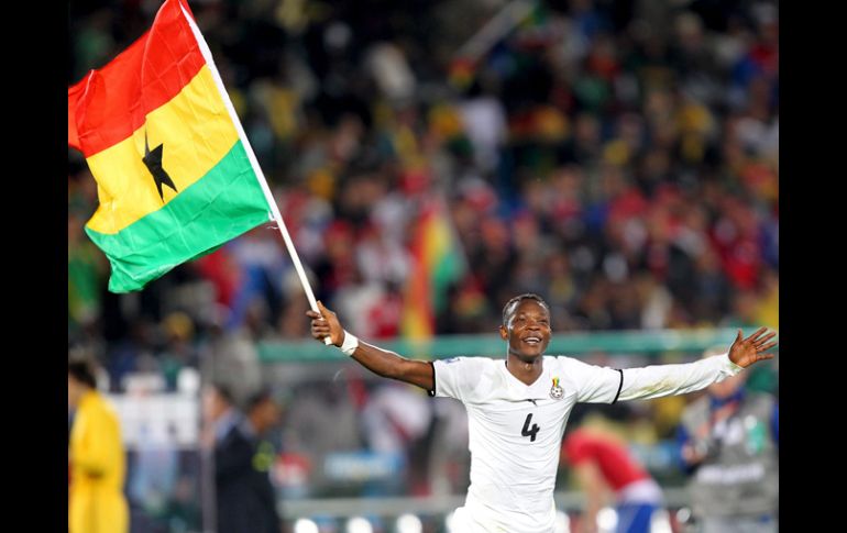 John Pantsil de Ghana celebra corriendo con la bandera de su país la victoria sobre Serbia. EFE  /