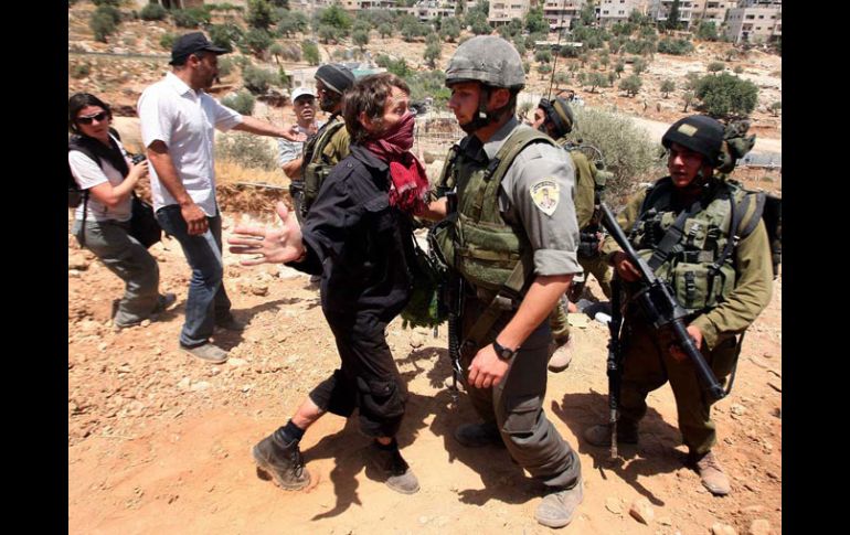 Militares israelíes confrontan a activistas que se inconforman por la barda fronteriza entre Israel y la ciudad cisjordana. AFP  /