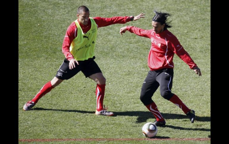 Los jugadores de la Selección de Suiza, Hakan Yakin (der.) y Goekhan Inler, se disputan el esférico. EFE  /