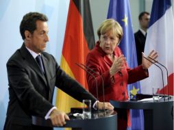 La canciller alemana Merkel y el presidente francés Sarkosy, comparecen ante los medios al término de un encuentro en Berlín. EFE  /