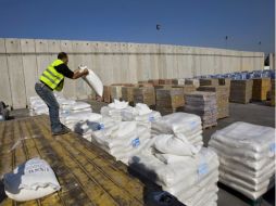 Un trabajador israelí mueve una bolsa de ayuda humanitaria de la ONU para Gaza. AP  /