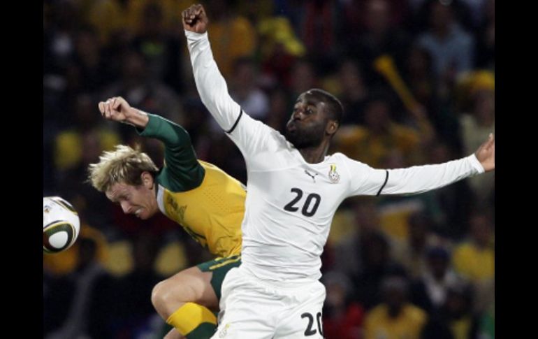 David Carney de Australia, (izq) y Quincy Owusu de Ghana. AP  /