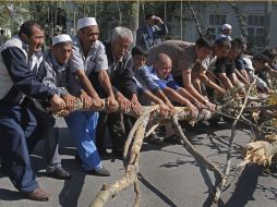 Uzbekos y kirguisos limpian barricadas de una calle, en el Sur de Osh. AP  /