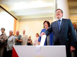 El candidato liberal Bronislaw Komorowski, deposita su voto junto a su esposa, Anna, en un colegio electoral de Varsovia. EFE  /