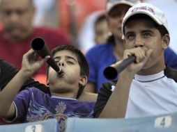 Fanáticos soplando la vuvuzela durante el partido de beisbol. AP  /