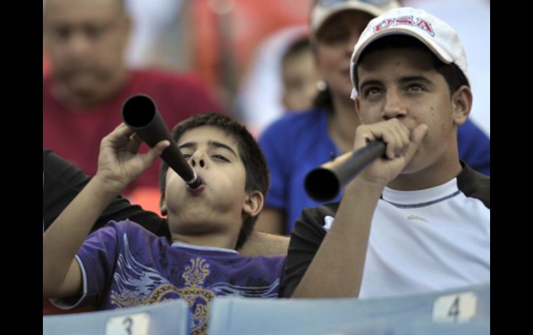 Fanáticos soplando la vuvuzela durante el partido de beisbol. AP  /