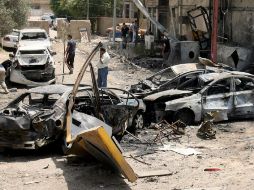 Iraquíes observan los daños causados por uno de los coches-bomba, en el Centro de Bagdad. EFE  /