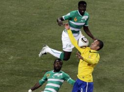 Luis Fabiano se apoya con uno de sus brazos para marcar el gol, ante las miradas de los marfileños. AP  /