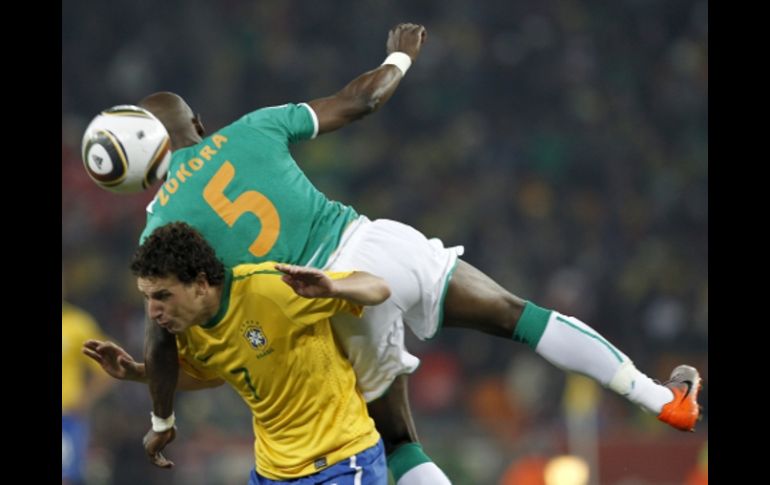 El jugador marfileño Didier Zokora (der) cae sobre el brasileño Elano (izq) en una acción del partido Brasil-Costa de Marfil. EFE  /