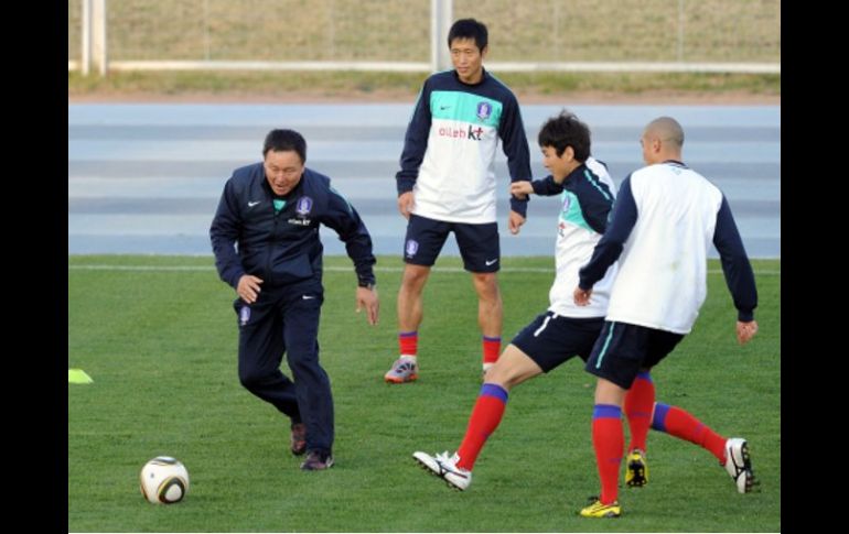 El técnico Huh Jung-Moo (izq.) entrena con sus seleccionados surcoreanos. AFP  /