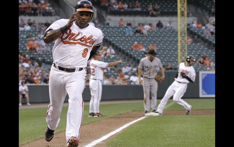 Miguel Tejada de los Orioles llega a home en la tercera entrada después del sacrificio de Luke Scott. AP  /