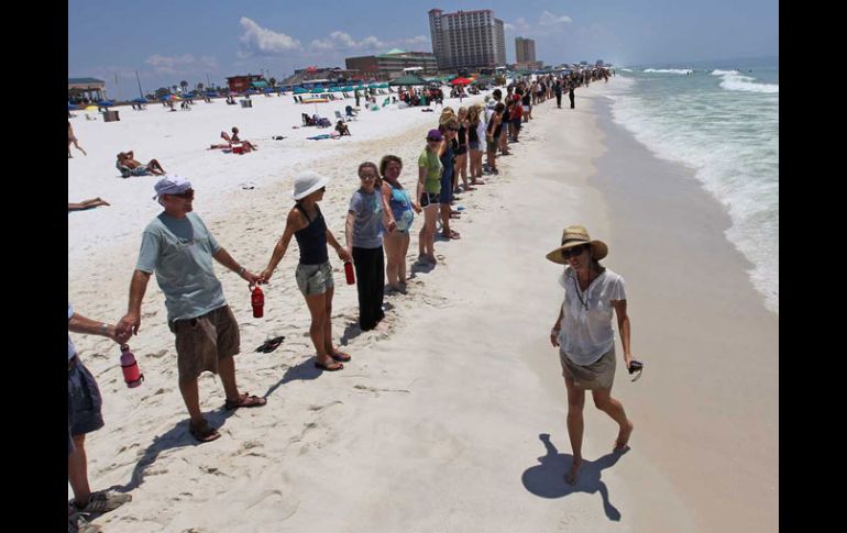 Residentes de Florida se unieron a la manifestación contra el derrame en el Golfo de México llamada “Manos a través de la arena”. AP  /