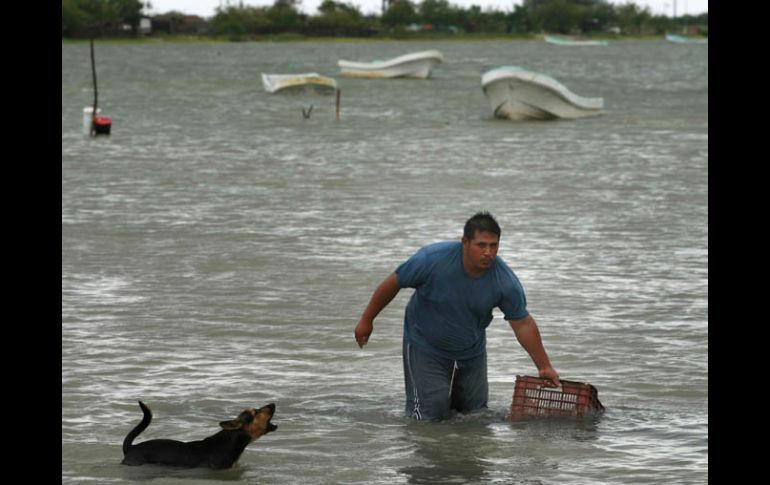 Un hombre traslada una caja a la orilla en La Carbonera, Tamaulipas, previo a la llegada del huracán. AP  /