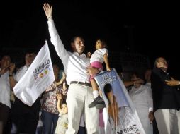 Gabino Cué alza la mano en señal de victoria luego de los resultados de encuestas de salida en Oaxaca. EL UNIVERSAL  /