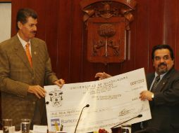 Durante la entrega del cheque por parte de la UdeG a la Crúz Roja, Miguel Ángel Domínguez y Marco Antonio Cortés Guardado. M. FREYRIA  /