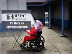 Una mujer acompaña a otra a emitir su voto en una casilla ubicada en Ensenada, Baja California. EFE  /