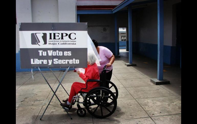 Una mujer acompaña a otra a emitir su voto en una casilla ubicada en Ensenada, Baja California. EFE  /