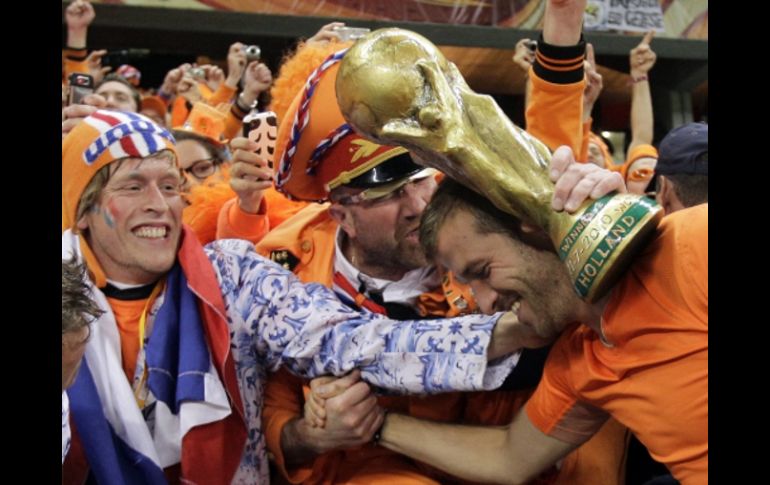 Un aficioando ofrece réplica del trofeo de la Copa del Mundo, al jugador de Holanda Rafael van der Vaart. AP  /