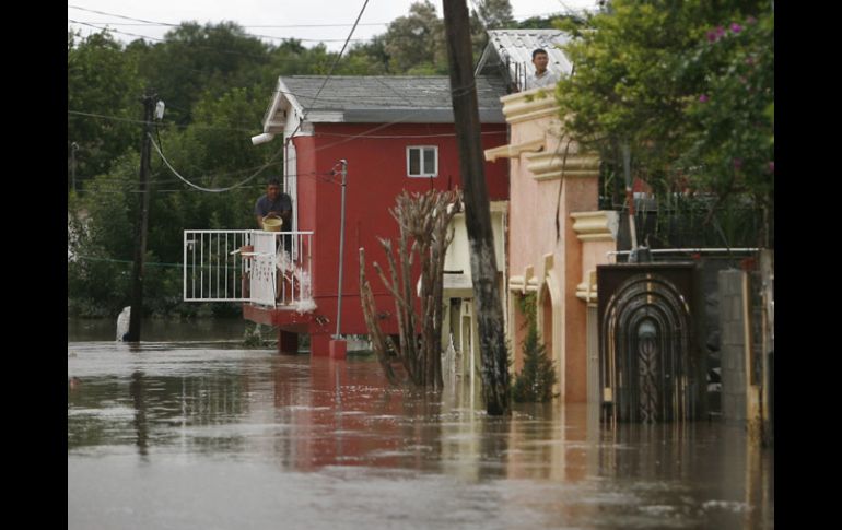 Un habitante de Nuevo Laredo saca agua del segundo piso de su casa. La crecida del Río Bravo afecta a Nuevo Laredo, Tamaulipas. AP  /