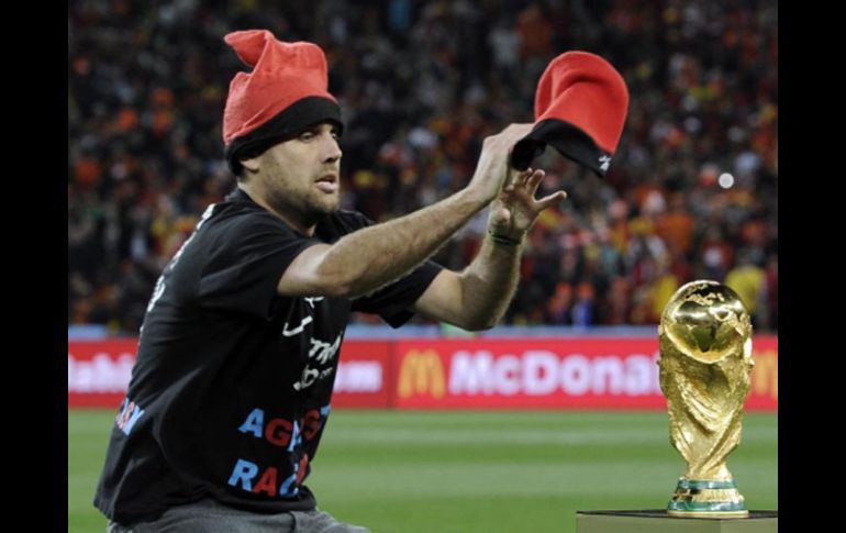 El aficionado en su intento por ponerle un gorro a la Copa del Mundo. AP  /