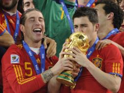 David Villa (der.) besa el trofeo junto al defensa Sergio Ramos. AFP  /