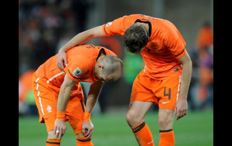 Joris Mathijsen (der.) consuela a su compañero Arjen Robben (izq.) tras caer derrotados en la final del Mundial. EFE  /