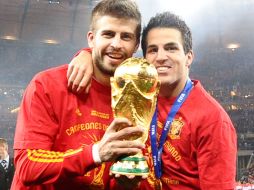 Los españoles Gerard Piqué y Cesc Fábregas cargan la Copa del Mundo. REUTERS  /