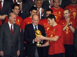 Iker Casillas (der.) muestra la Copa del Mundo a el rey Don Juan Carlos (centro). AFP.  /