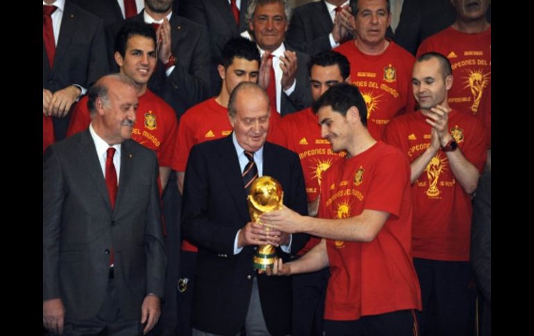 Iker Casillas (der.) muestra la Copa del Mundo a el rey Don Juan Carlos (centro). AFP.  /