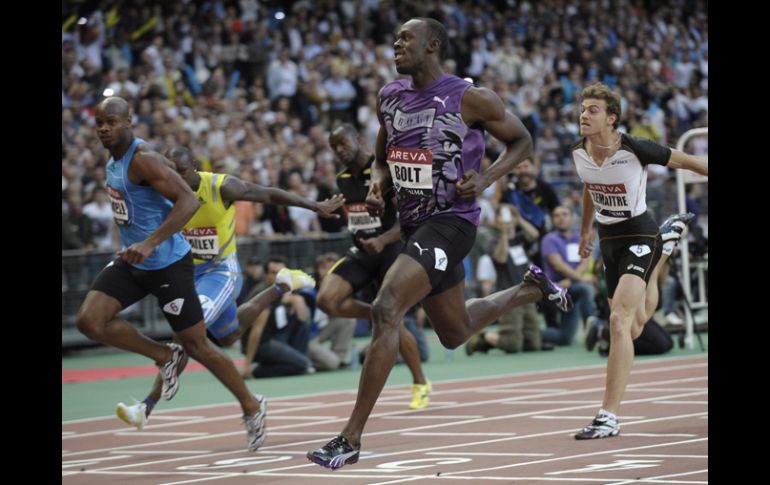 Usain Bolt tuvo que hacer un doble esfuerzo para rebasar a Powell y ganar la carrera con muy poco margen. EFE  /