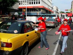 Varios jóvenes vestidos con playera roja entregaron volantes informativos a los automovilistas en el Centro de la Ciudad. E. PACHECO  /