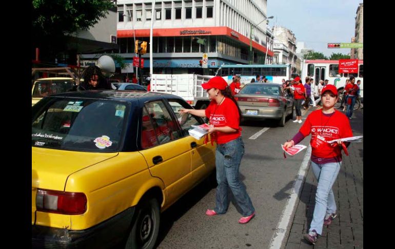 Varios jóvenes vestidos con playera roja entregaron volantes informativos a los automovilistas en el Centro de la Ciudad. E. PACHECO  /