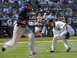 A.J. Burnett recoje la bola mientras Ben Zobrist corre a primera durante la segunda entrada. AP  /