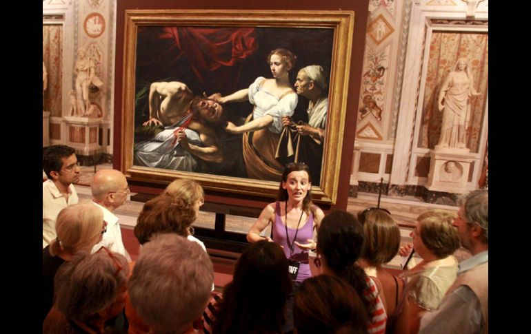 Visitantes escuchan la explicación de una guía sobre el cuadro 'Judit decapitando a Holofernes'. EFE  /