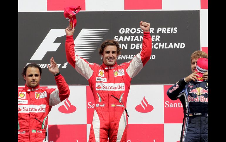 Alonso (al centro) y Massa (izq), festejan moderadamente, luego de la controversia que se dio con su equipo en la pista. EFE  /