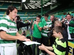 Efraín Juárez firmando autógrafos a los fanáticos. AP  /